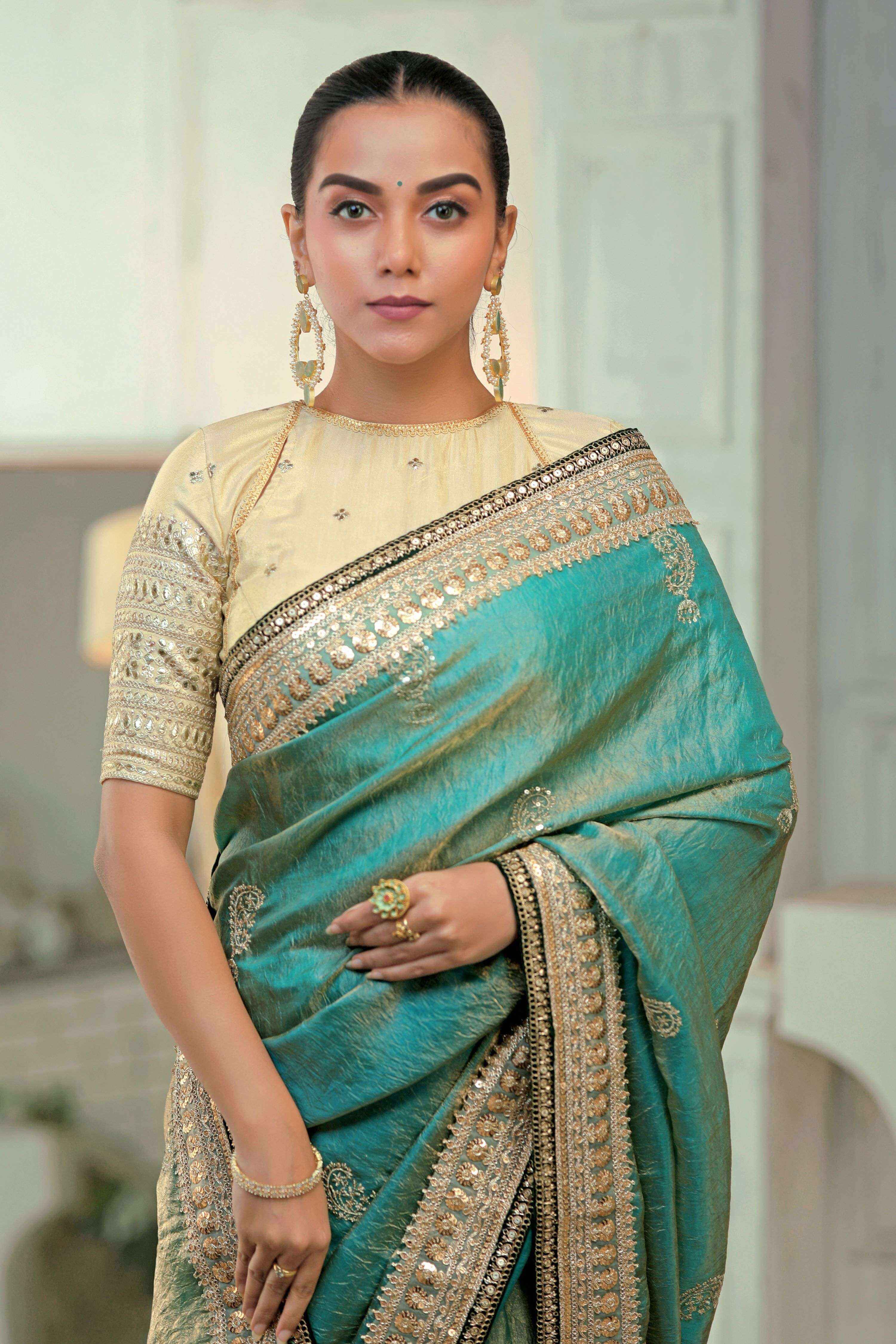 AQUA AMOUR SAREE WITH THE CLASSIC CHAMPAGNE BLOUSE featuring teal blue saree with champagne blouse and embroidered details.