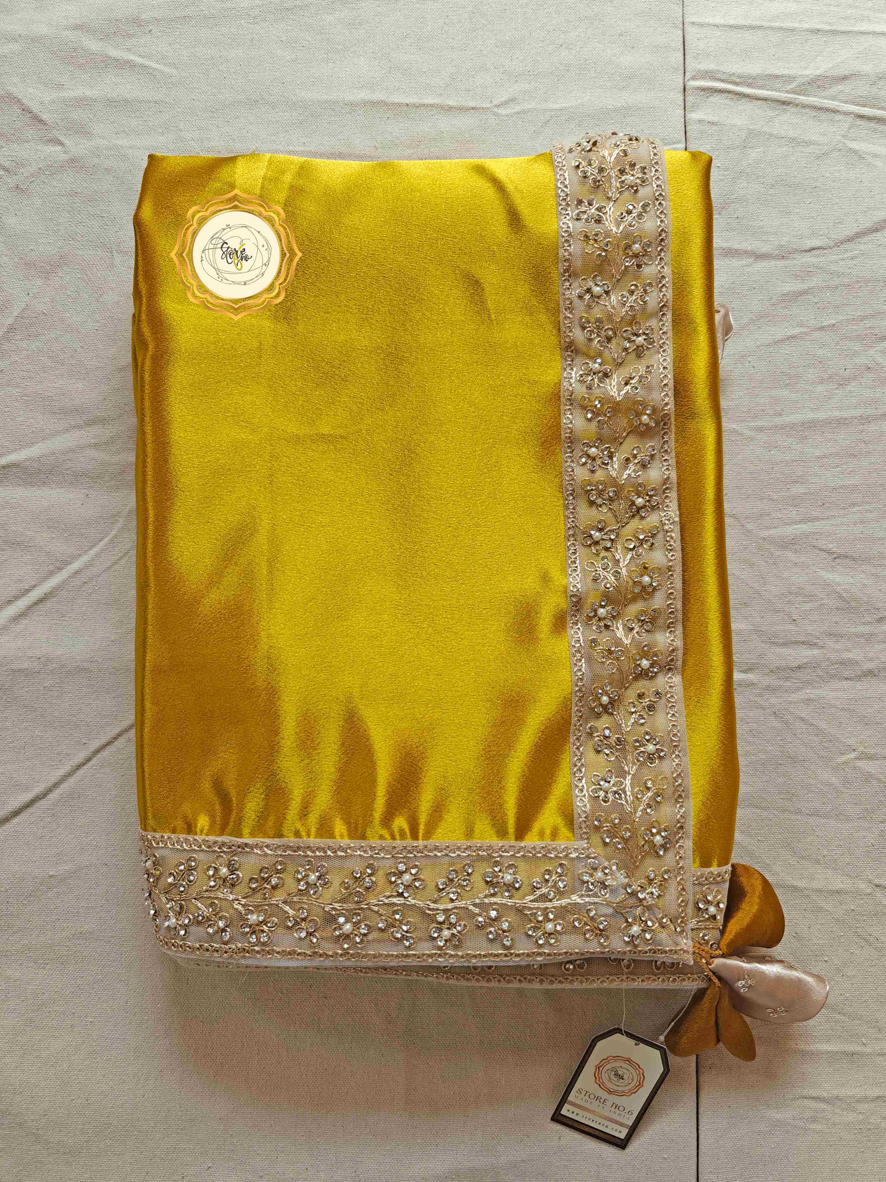 Elegant satin saree with blouse featuring yellow fabric and intricate border design.