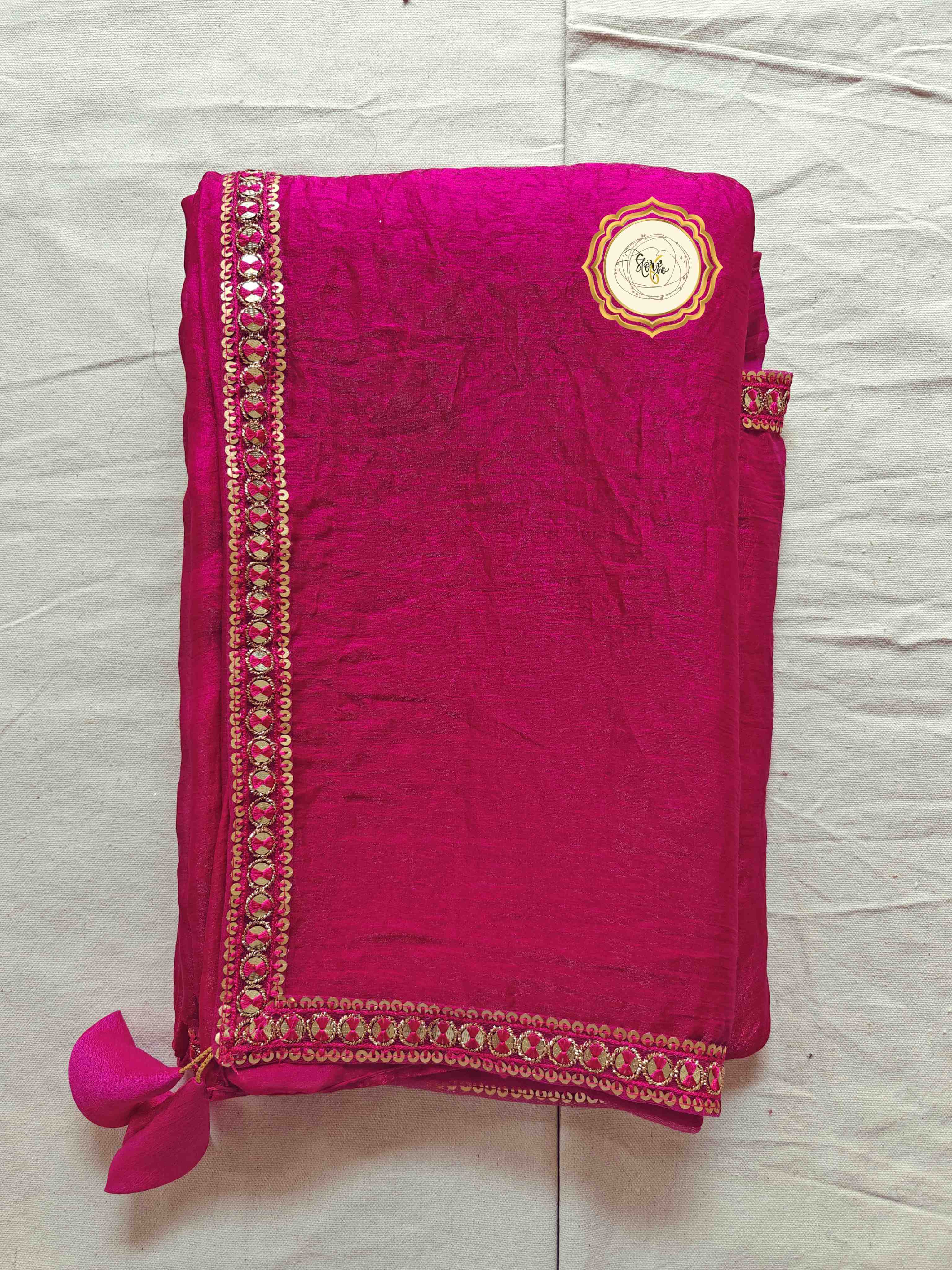 premium pink saree with unstitched blouse folded with embellishments and tassels on the edge.