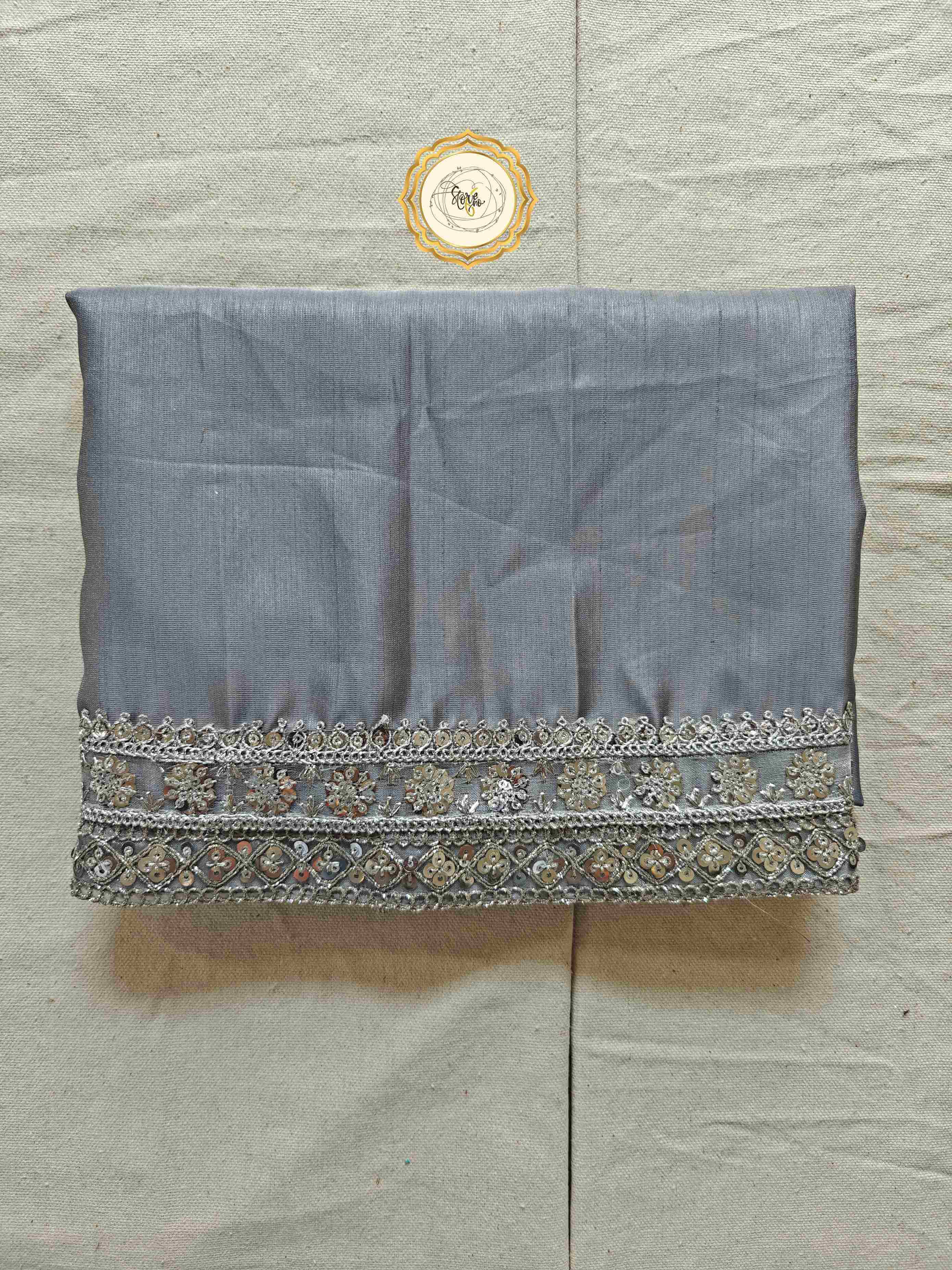 silver organza saree with blouse, showcasing intricate lace work and a luxurious fabric texture.